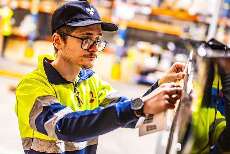 IGL intégrateur de solutions — opérateur scannant un code-barres en entrepôt de logistique marketing